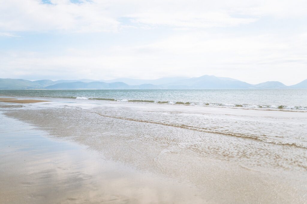 Wide, minimalist view of rolling tides and soft sand at Inch Beach Ireland, perfect for fine art prints.